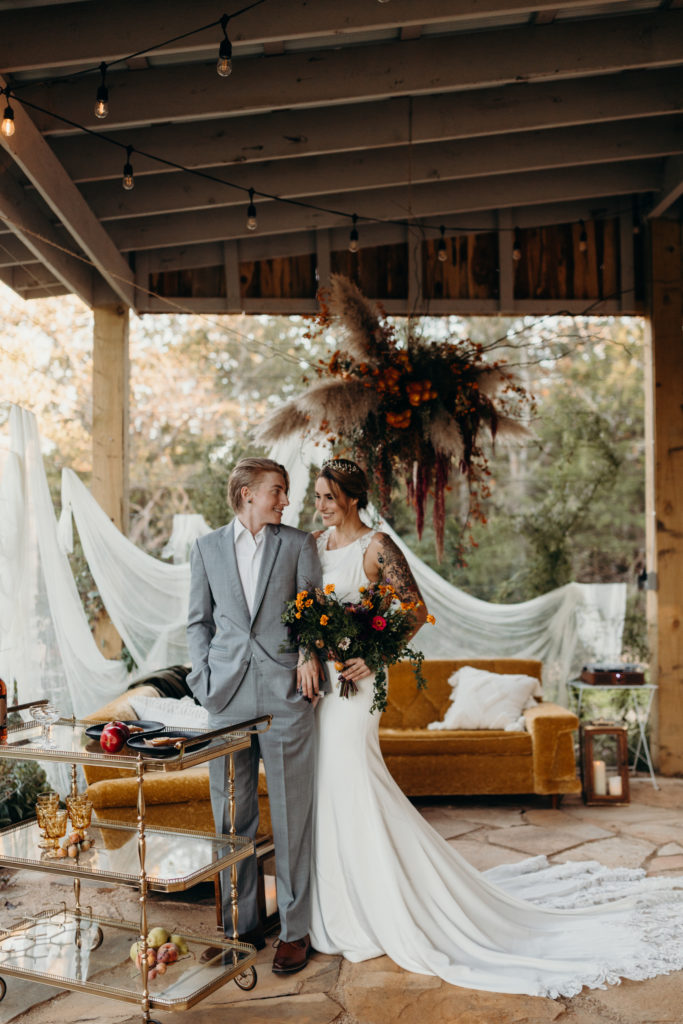 Nontraditional wedding couple at outdoor wedding with vinyl records and midcentury furniture