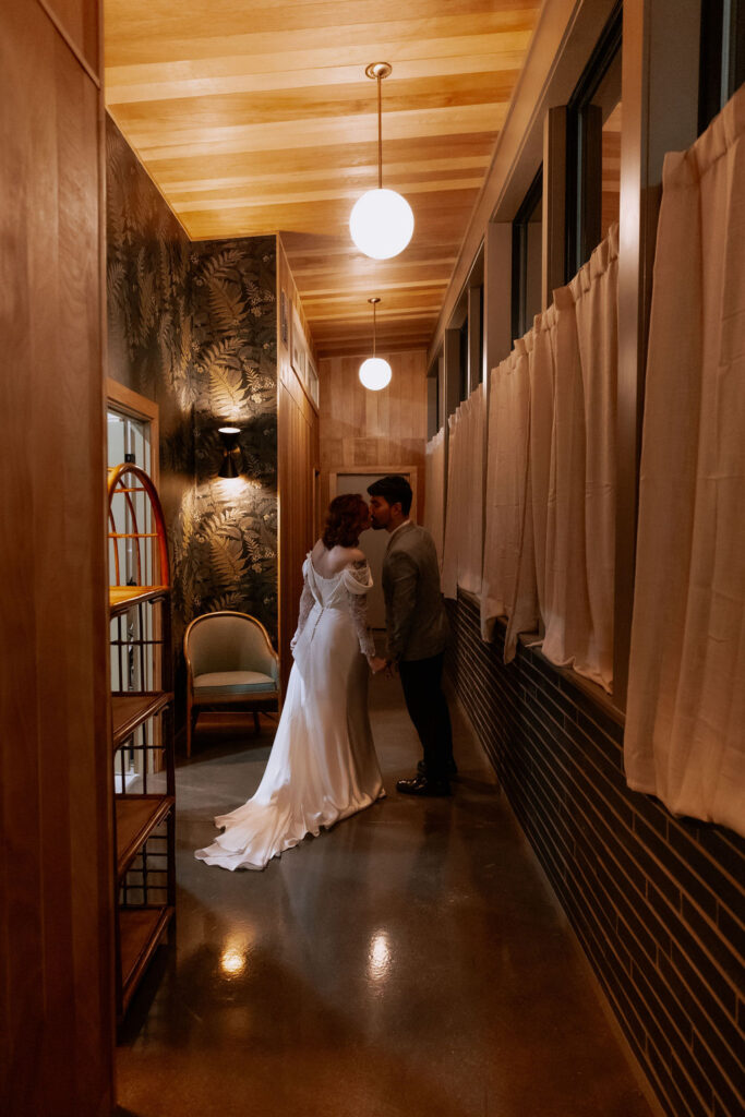 couple kiss in a mid-century modern hallway at the end of the night