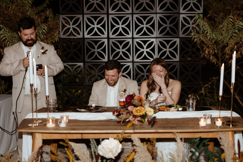 couple laughing during speech in outdoor wedding